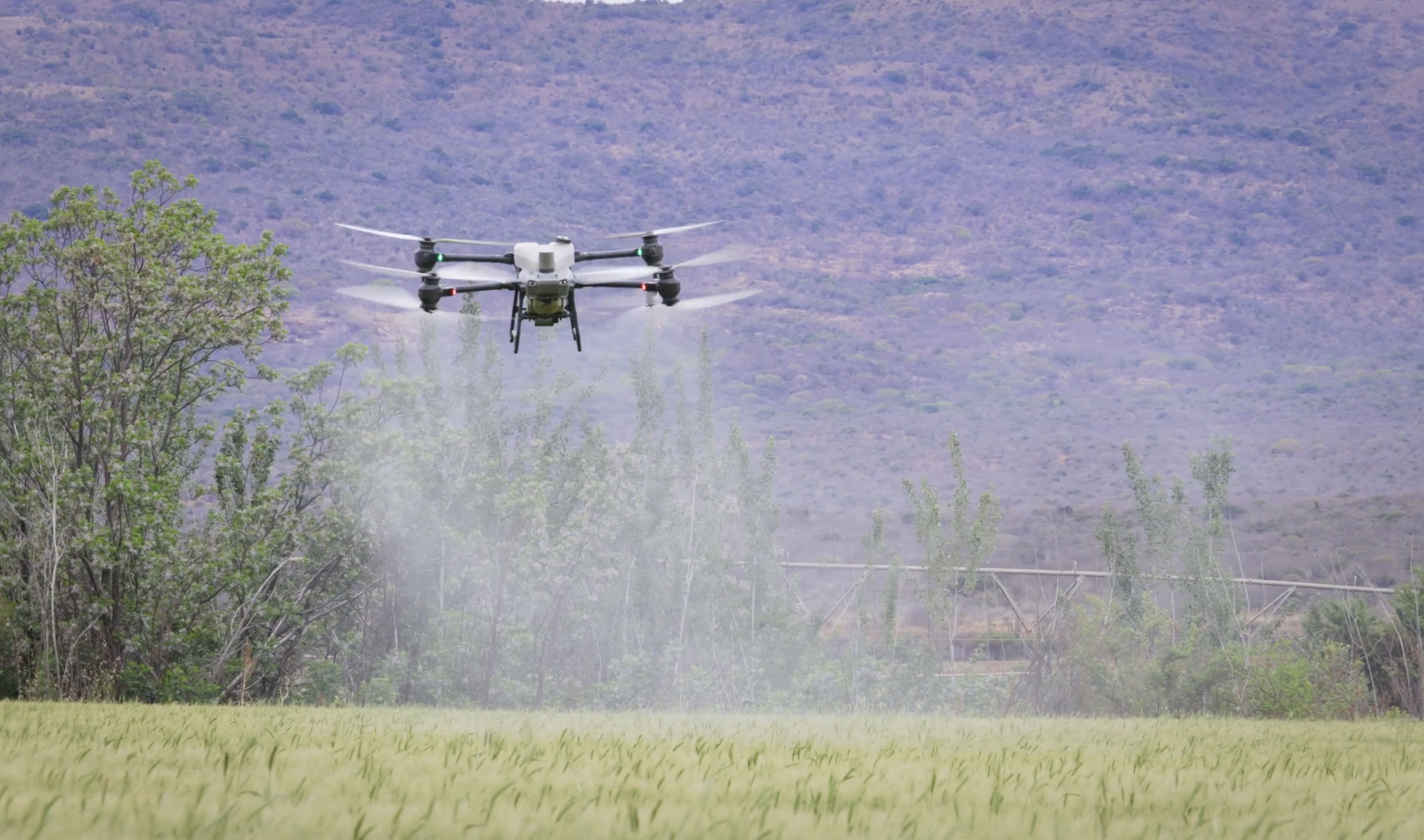 Agricultural drone spraying crops over a farm field